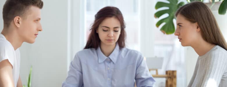 UnhappyYoungMarriedCoupleSittingOppositeGettingDivorcedInLawyer